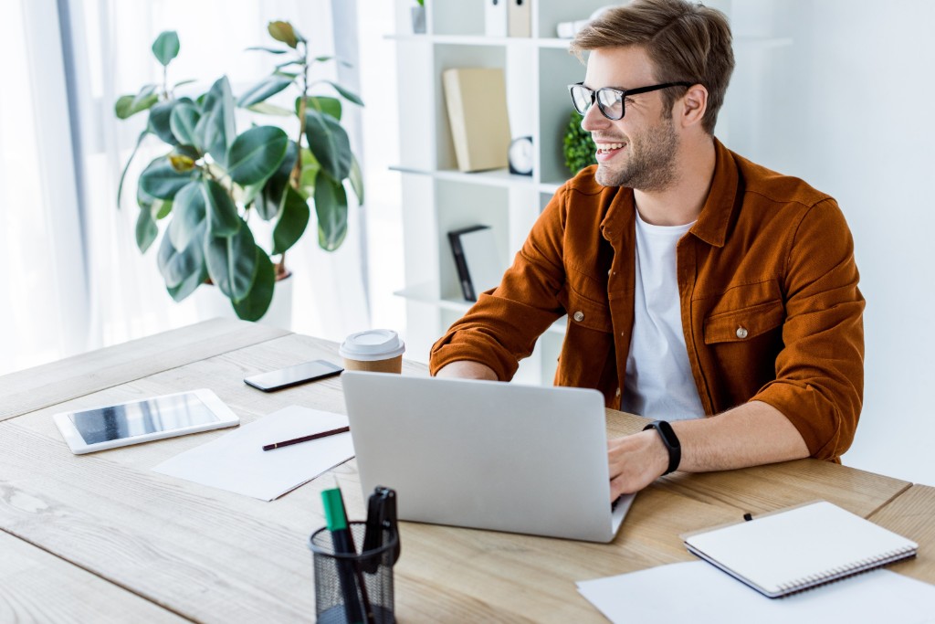 Man Works On A Laptop Wearing Glasses