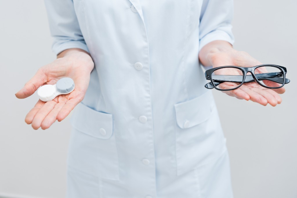 Doctor Holding Glasses And Drops In His Hand